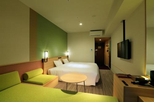 a hotel room with a bed and a table and a couch at THE SINGULARI HOTEL & SKYSPA at UNIVERSAL STUDIOS JAPAN in Osaka