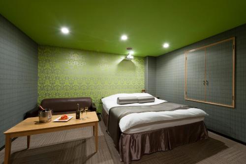 a small room with a bed and a table at ホテル ブランチャペルクリスマス 四日市 in Yokkaichi