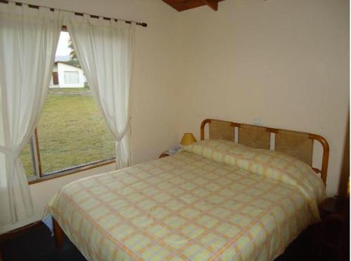 a bedroom with a bed and a large window at Cabañas 4 Esquinas in La Serena