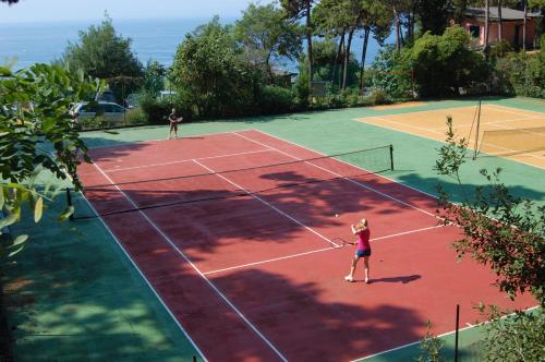 2 persone che giocano a tennis su un campo da tennis di Resort La Francesca a Bonassola