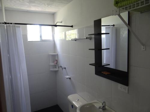 a white bathroom with a sink and a mirror at Palestina Ecohotel in Chinchiná