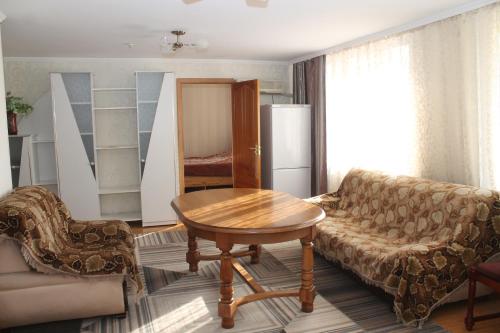 uma sala de estar com uma mesa e um sofá em Semey Hotel em Semey