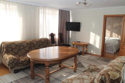 a living room with a table and a couch at Semey Hotel in Semey