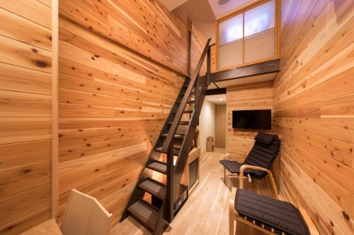 a house with a spiral staircase in a room with wooden walls at Hotel Miyajima Villa in Miyajima
