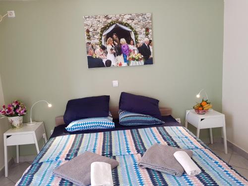 ein Schlafzimmer mit einem Bett mit einem Bild an der Wand in der Unterkunft Sounio Palea Heaven in Palaia Fokaia