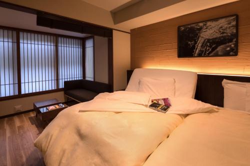 a bedroom with a bed with a book on it at Hotel Miyajima Villa in Miyajima