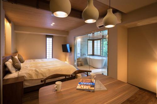 a bedroom with a bed and a bathroom with a tub at Hotel Miyajima Villa in Miyajima