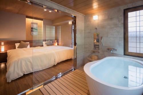 a bathroom with a bed and a bath tub at Hotel Miyajima Villa in Miyajima