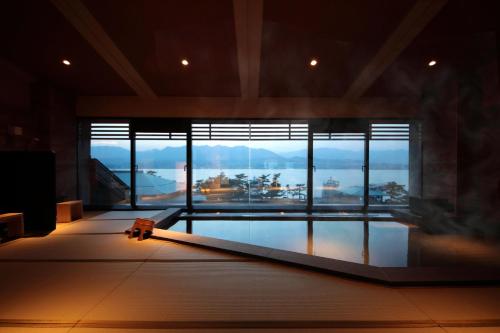 Habitación con piscina y ventana grande. en Hotel Miyajima Villa en Miyajima
