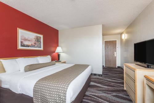 a hotel room with a large bed and a flat screen tv at Days Inn by Wyndham Gillette in Gillette