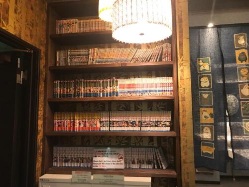 a book shelf filled with lots of dvds at HOSTEL WASABI Nagoya Ekimae in Nagoya