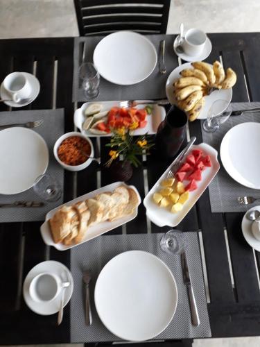 a table topped with white plates and bowls of food at South House-Weligama in Weligama