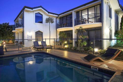 a swimming pool in front of a house at Delorenzo Studio Apartments in Nelson