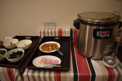 a table with a plate of food and a pot at Hotel Crown Hills Toyokawa in Toyokawa