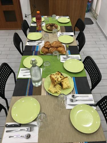 a long table with green plates of food on it at Top Floor Rentrooms Napoli in Naples