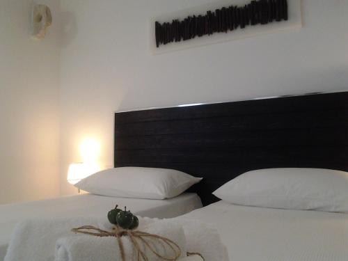 a bedroom with two beds with white sheets and a black headboard at Arco' B&B Trani Cattedrale in Trani