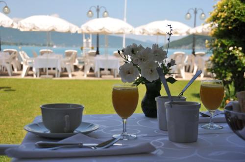 - une table avec des verres de jus d'orange et des fleurs dans l'établissement Auberge Du Roselet, à Duingt