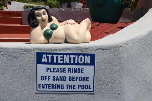 a sign on a wall with two statues of women at Breakerview in Shelly Beach