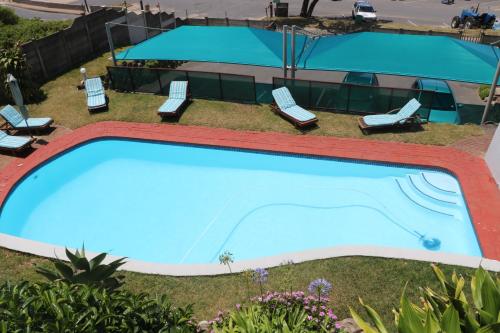 an overhead view of a swimming pool with chaise lounge chairs and a resort at Breakerview in Shelly Beach