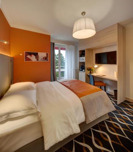 a bedroom with a large bed and a desk at Hotel Eden in Geneva