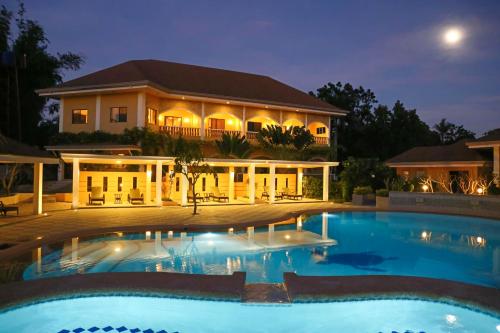 a large building with a swimming pool at night at Turtle Bay Dive Resort in Moalboal