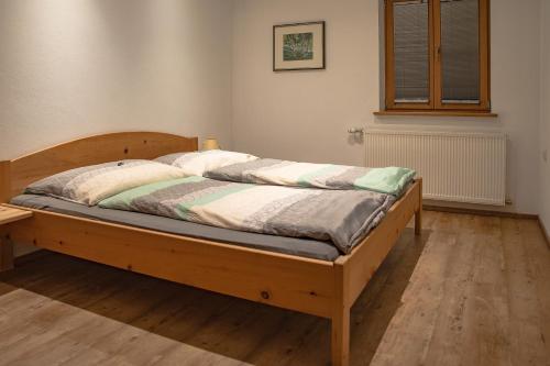 1 dormitorio con cama de madera en una habitación en Apartment Bachmaier, en Bramberg am Wildkogel
