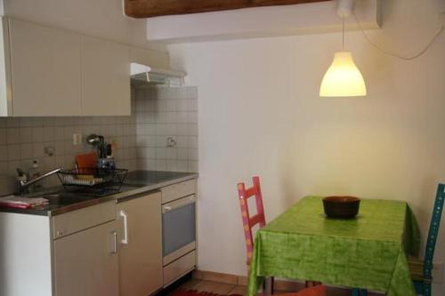 a kitchen with a table and a green table and chair at Ca di Stremb in Maggia