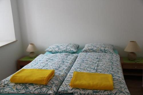 Una cama con dos almohadas amarillas encima. en Ca di Stremb, en Maggia