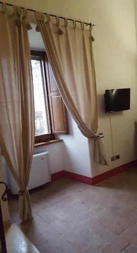 a room with a curtain and a window at Torre della Botonta in Castel Ritaldi