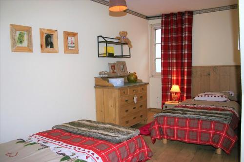 a bedroom with two beds and a dresser and a window at My Sweet Homes - Le 15 in Colmar