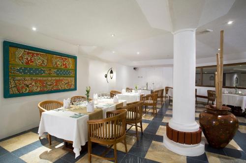 a restaurant with tables and chairs and a painting on the wall at SOL by Meliá Benoa Bali All inclusive in Nusa Dua