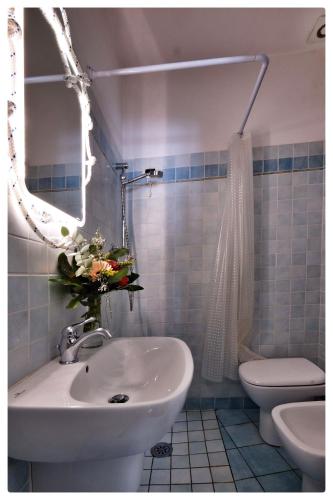 a bathroom with a sink and a toilet and a mirror at La Casa sul Molo in Viareggio
