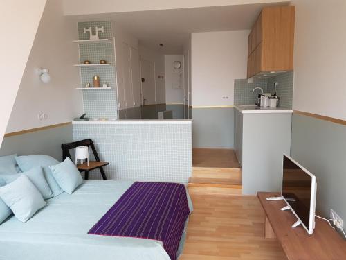 une petite chambre avec un lit et une cuisine dans l'établissement Appartement de charme vue mer, à Deauville