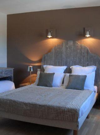 um quarto com uma cama grande e almofadas brancas em chambres "gard'échoise" em Barjac