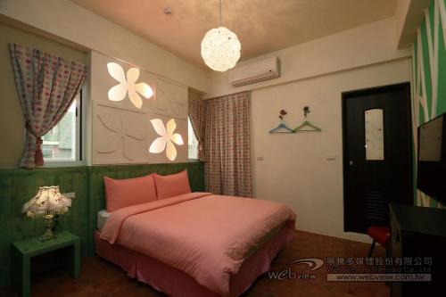 a bedroom with a pink bed and a window at Bear Homestay in Taitung City