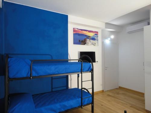 a room with two bunk beds with blue walls at Pavia Ostello in Pavia