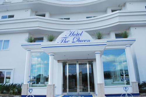 a white building with a sign that reads hotel the queen at Hotel The Queen in Pastorano