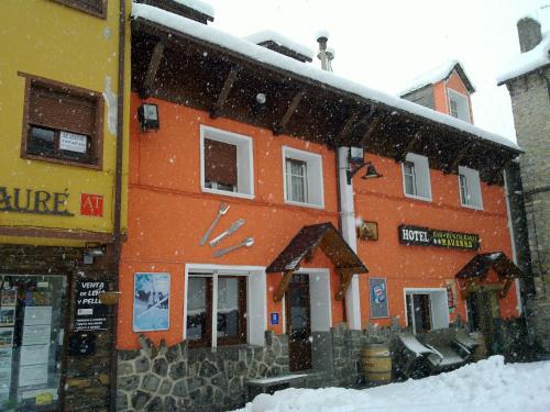 an orange building with snow falling in front of it at Hotel Navarro in Panticosa