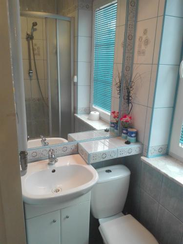 a white bathroom with a sink and a toilet at Agroturystyka Relaks in Orzeszkowo