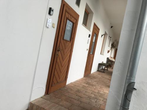 a wooden door on a white wall with a staircase at Weingut Martinshof in Sankt Ulrich
