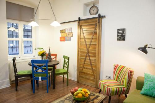 a room with a table and chairs and a wooden door at Apartment Milk&Honey - free Parking in Sarajevo