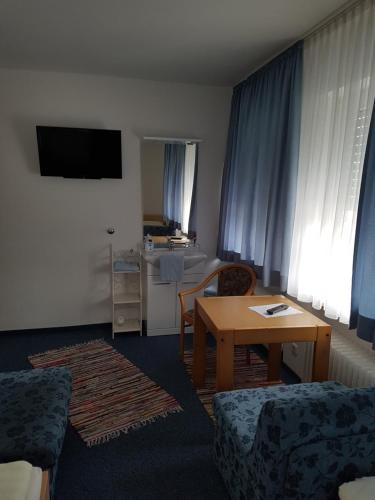 a living room with a table and a room with a kitchen at Hotel Giesing in Munich