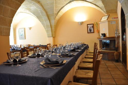 a long table in a room with chairs and wine glasses at Al Borgo Antico Ristorante e B&B in Crispiano