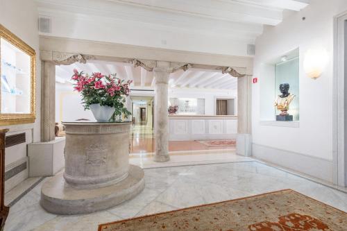 a large room with a vase with flowers in it at Hotel Ai Reali - Small Luxury Hotels of the World in Venice