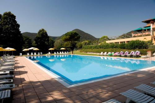 a large swimming pool with chairs and umbrellas at Relais Golf Padova in Galzignano