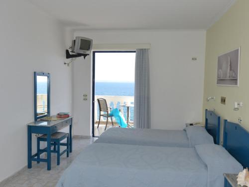 a bedroom with a bed and a view of the ocean at Ostria Seaside Studios and Apartments in Katarráktis