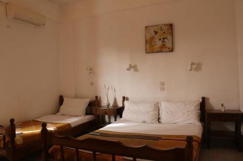a room with two beds and a picture on the wall at Rent Rooms Katerina in Kalamaki Heraklion