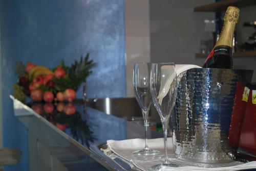 a bottle of wine and two wine glasses on a table at Hotel The Queen in Pastorano