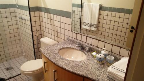 a bathroom with a sink and a toilet at Apto Cond. Porto Ventura 3 quartos in Florianópolis