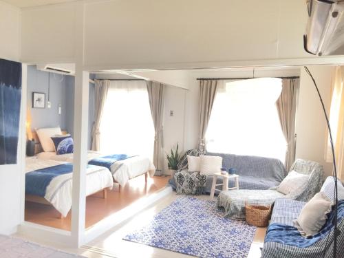 a bedroom with two beds and a couch at Holiday Homes TSUBOYA 601 in Naha